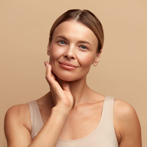 Smiling Woman Touching Face. Waist up Portrait of Attractive Woman Touching her Skin and Smiling. Woman Appearance and skin Care Concept